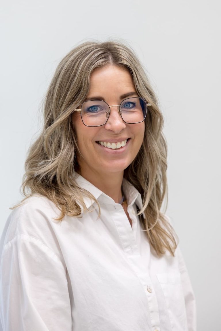 Professioneel portret van Britte, baliemedwerkster bij TandZuiver, met een gastvrije glimlach in haar werkomgeving.