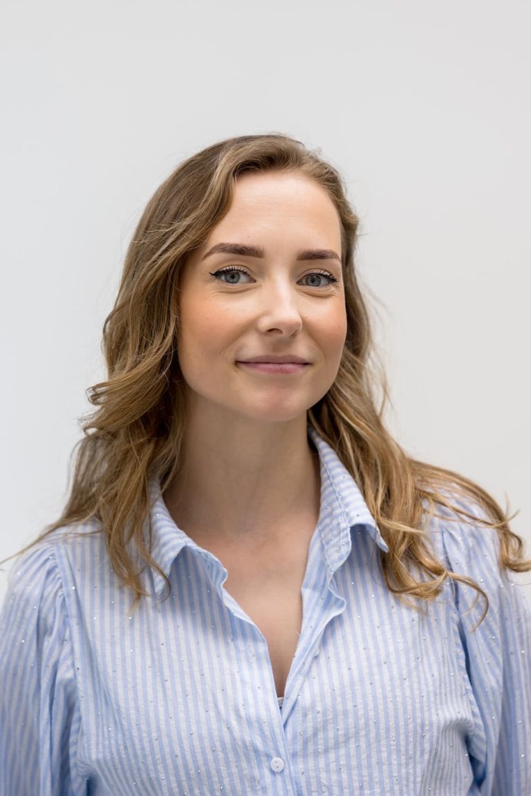 Portret van Rebecca Kemp, assistente bij TandZuiver, die warm glimlacht in een professionele omgeving.