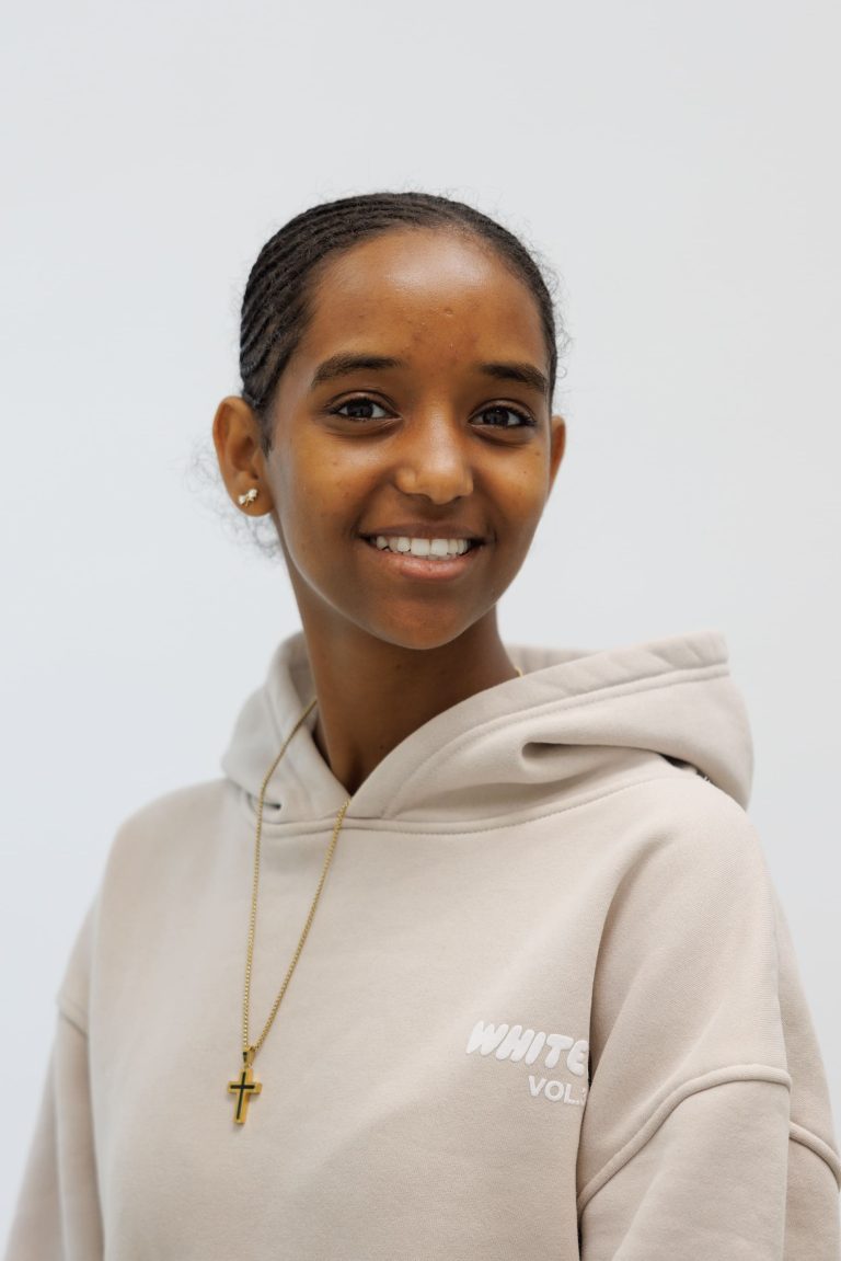 Portretfoto van Asmayt, assistent in opleiding werkzaam bij TandZuiver, glimlachend.